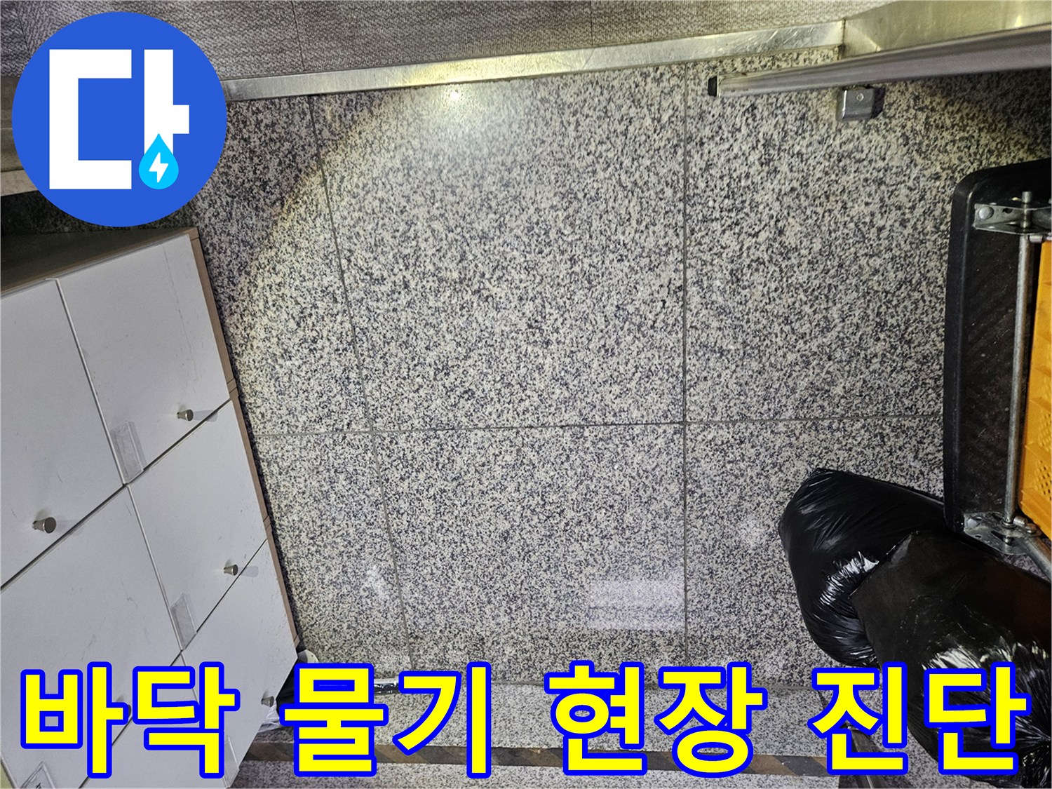 포천 아파트의 바닥 타일에서-누수로 인한 물기 흔적을 발견하고-정확한 누수 지점을 찾기 위한-전문가의 면밀한 점검이 이루어지고 있습니다