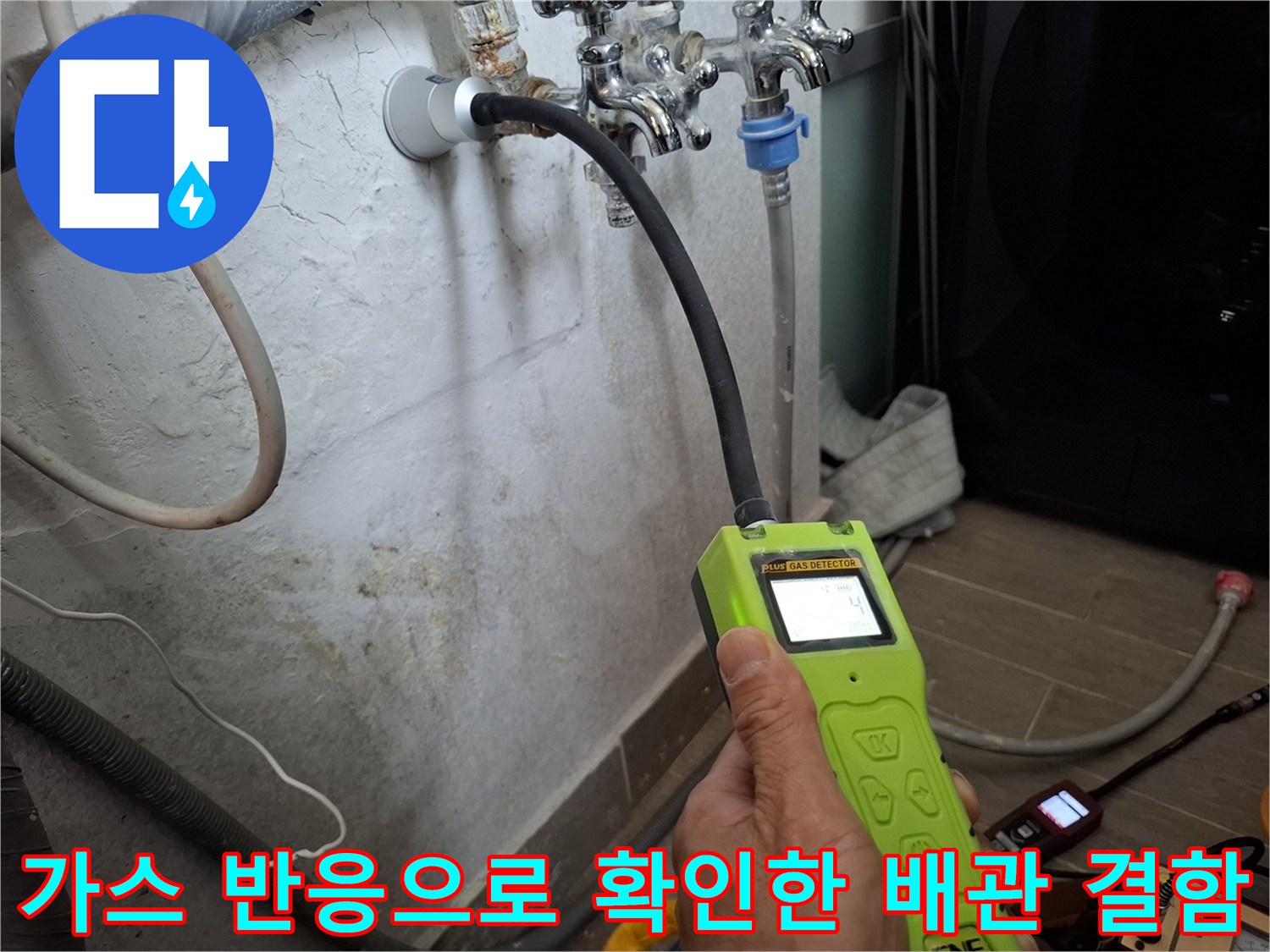 배관 연결 부위 근처에서 가스 탐지기 수치를 체크하는 손