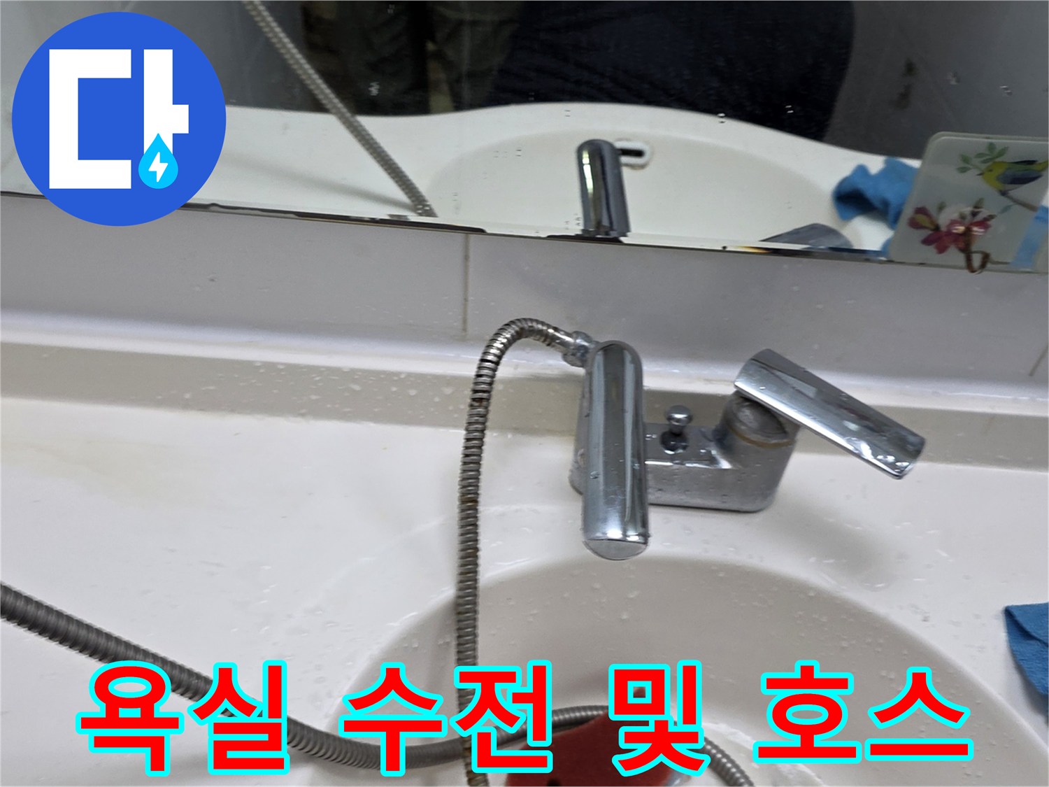 세면대 수전과 샤워기 호스가 연결된 화장실 내부 모습입니다.