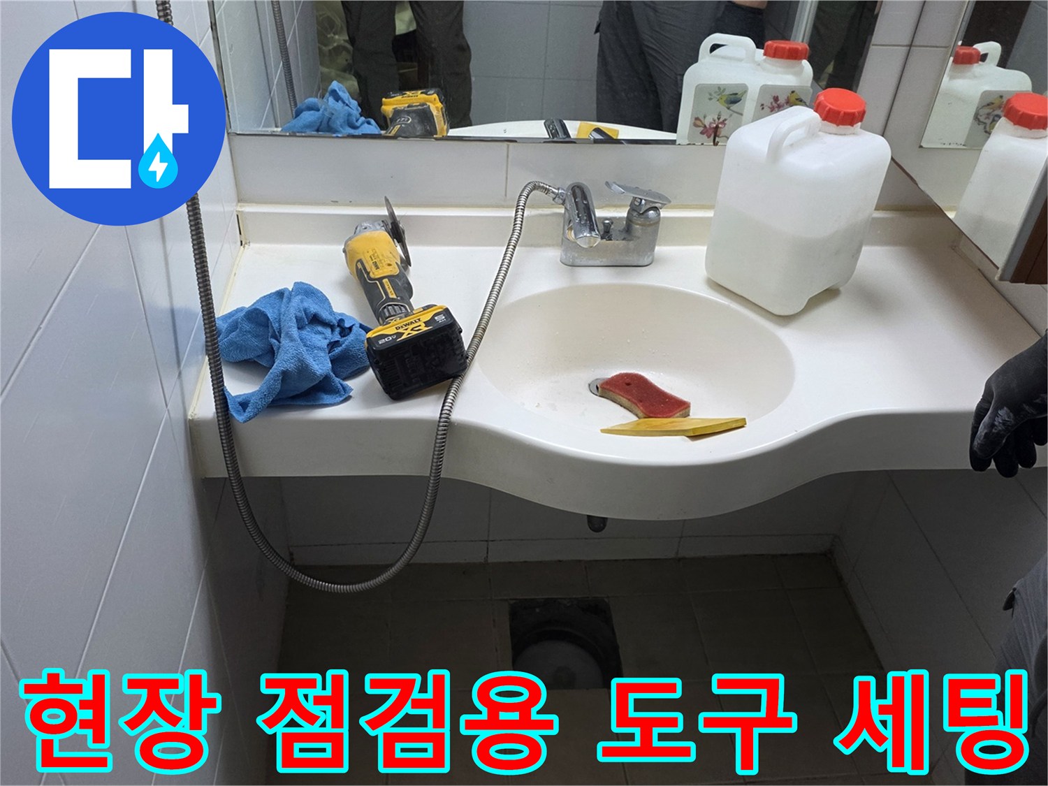 세면대 하부 작업 공간에 배치된 점검 도구와 방수 자재들입니다.