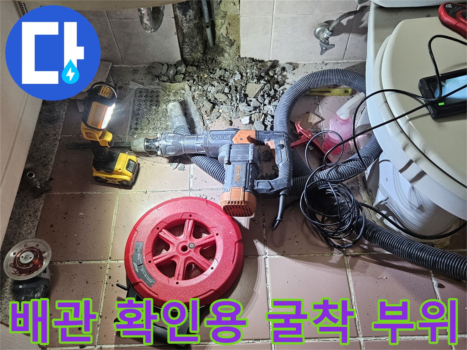 세면대 밑 배관 누수를 확인하기 위해 타일을 깨고 작업 중인 모습