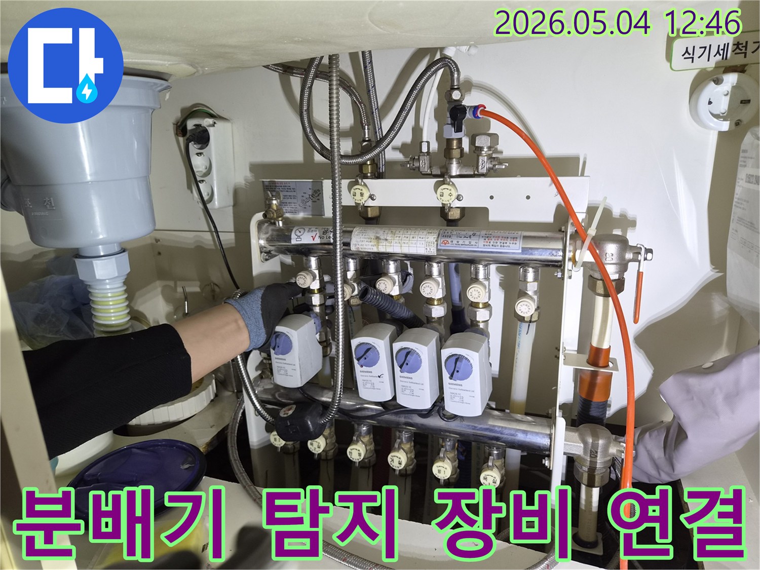 누수 엔지니어가-성동구 아파트에서-누수 탐지를 위해-보일러 분배기에-전문 장비를 연결하는 모습