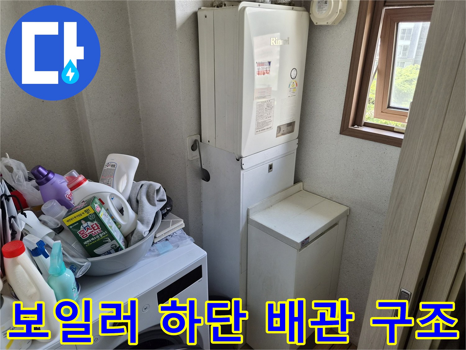 보일러실 내부의 보일러와 주변 배관 및 세제류가 놓인 모습입니다.