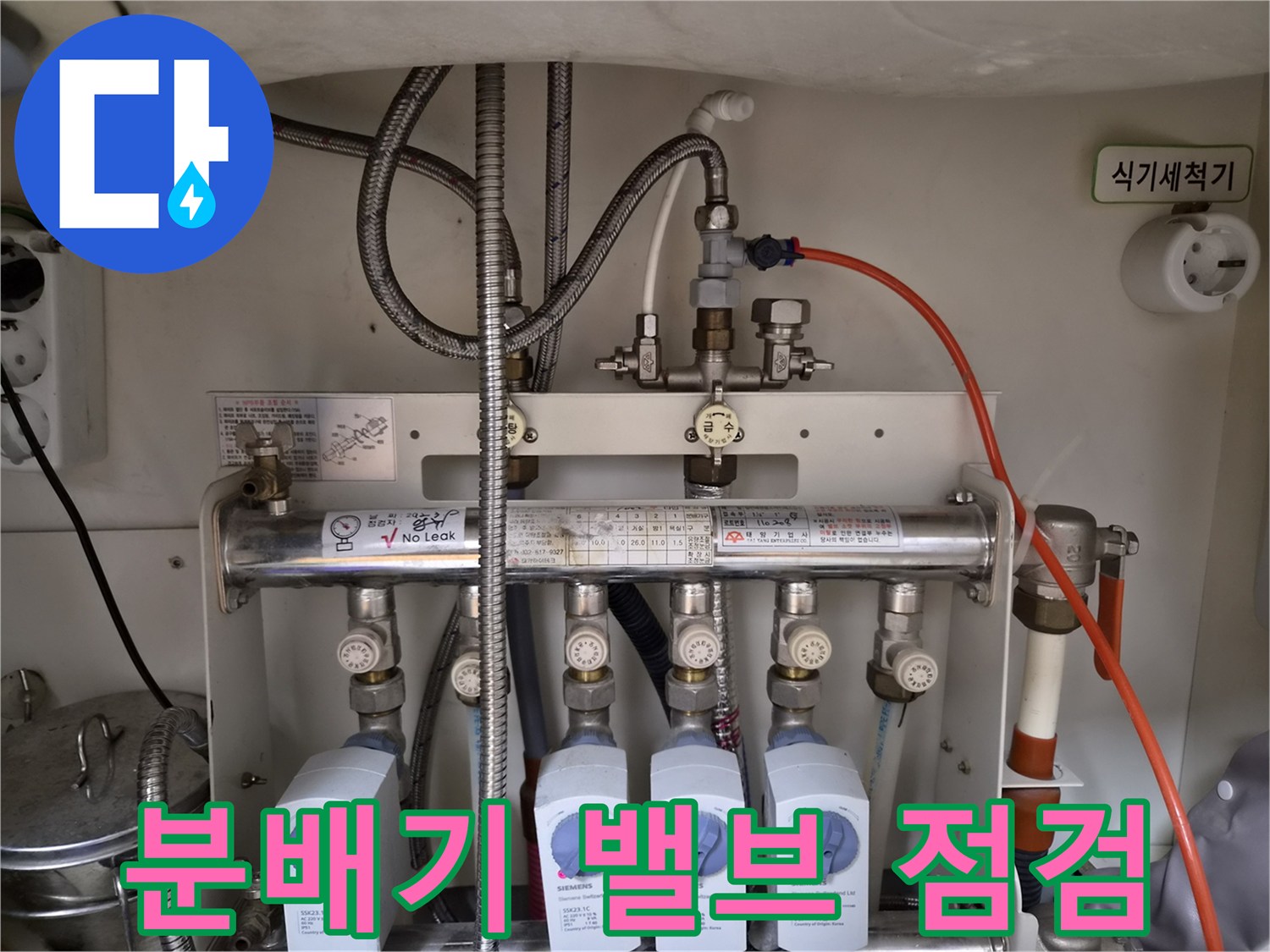 싱크대 하단에 위치한 금속 배관과 유량 조절 장치