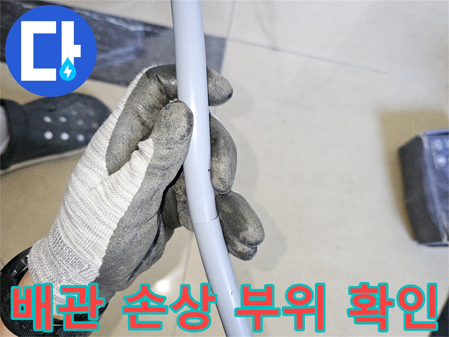 엔지니어가 파손된 회색 배관의 상태를 면밀히 살핌
