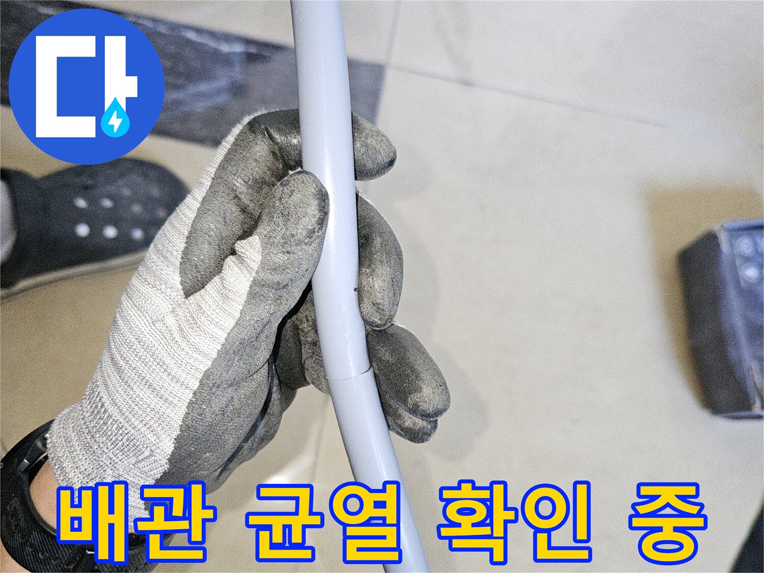 작업자가-회색-배관의-손상-부위를-조사하는-모습