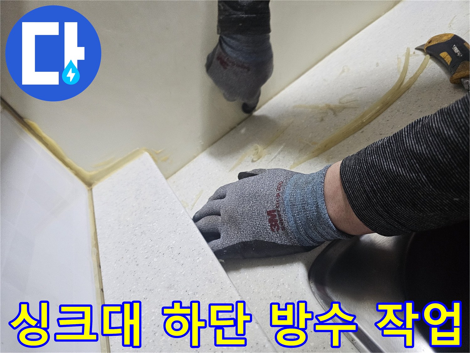 엔지니어가 장갑을 착용하고 싱크대 틈새에 실리콘을 시공하는 장면