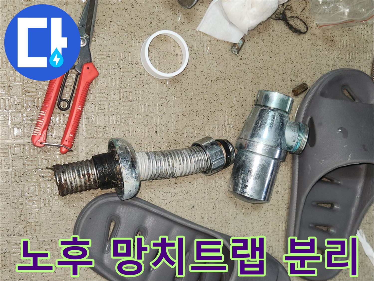 오랜 시간 사용으로 부식된 망치트랩 부품들이-누수 해결을 위해 바닥에 놓여 있습니다