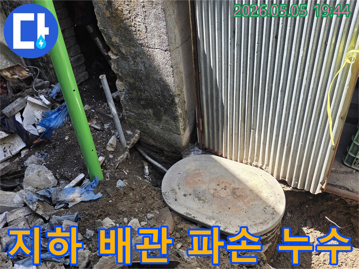 창고 건물 지하에 묻힌-배관이 파손되어-누수가 발생한 현장을-전문가가 긴급하게-복구하는 모습입니다.