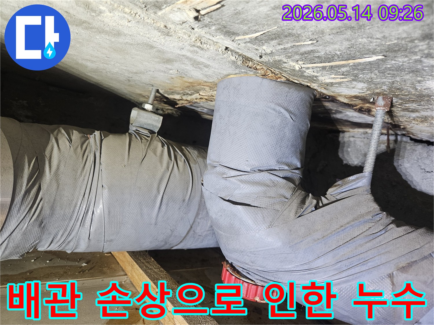 천장 배관의 단열재가 젖고-물이 새어 주변 목재가 손상된-누수 현장을 보여줍니다