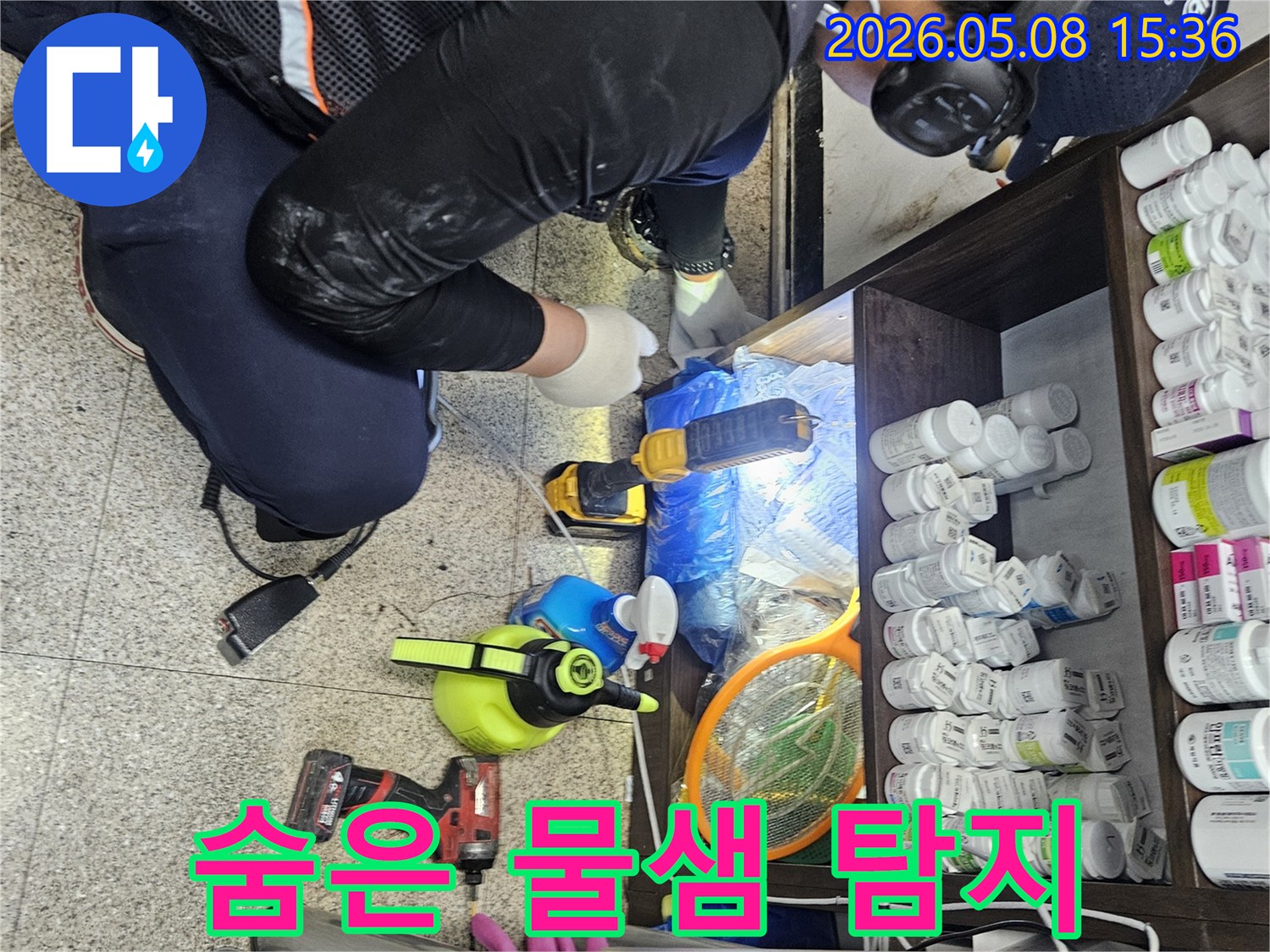누수 탐지 전문가가-좁고 어두운 공간에서-손전등을 비추며-숨겨진 물샘을-찾아내고 있습니다.