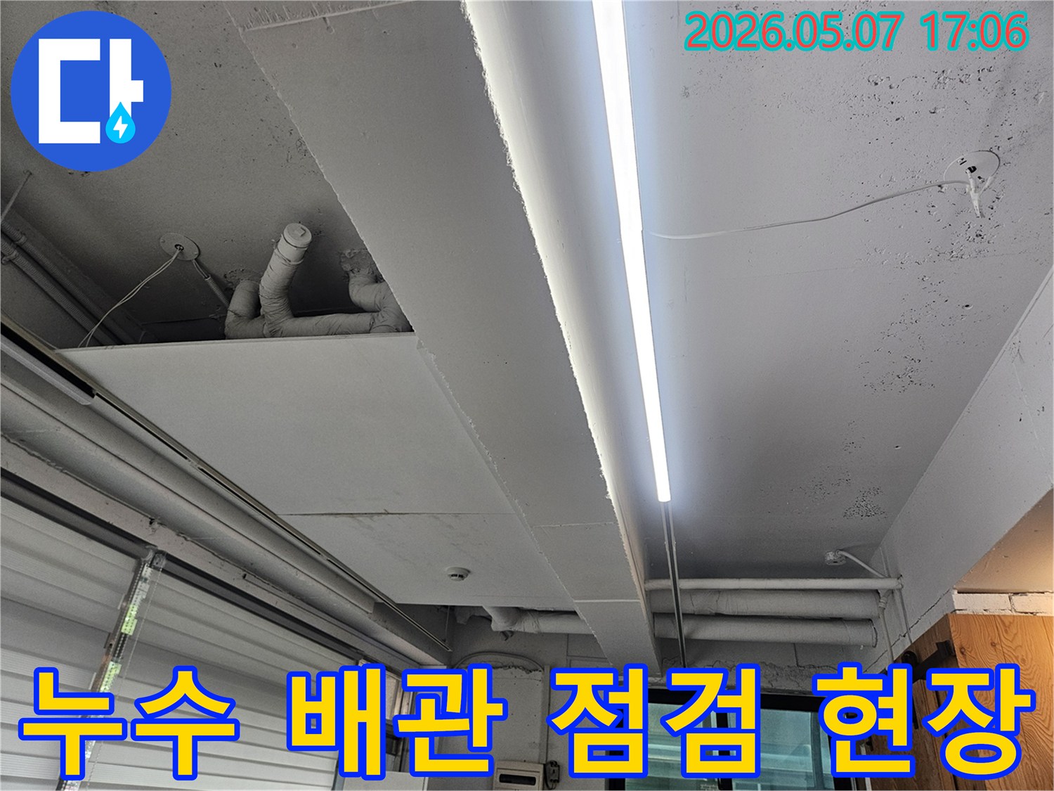 누수 공사 현장의-천장 배관과-조명 시설을 보여주는-이미지입니다