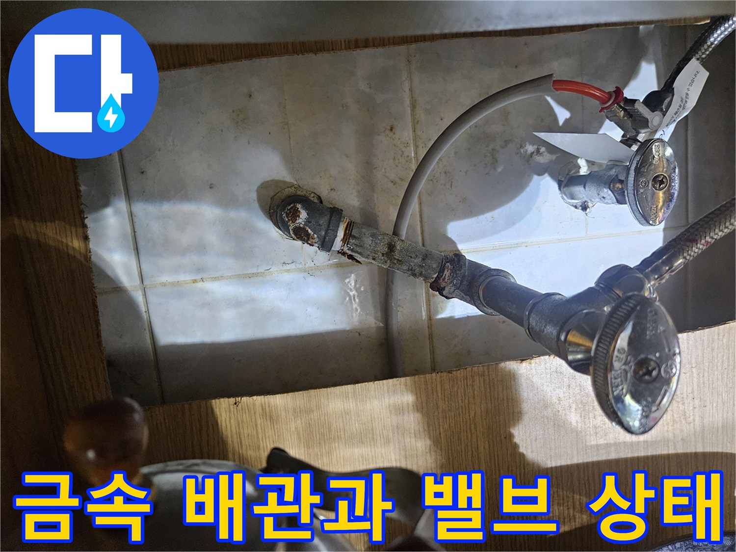 벽체에 고정된 금속 배관과 조절 밸브의 근접 촬영본