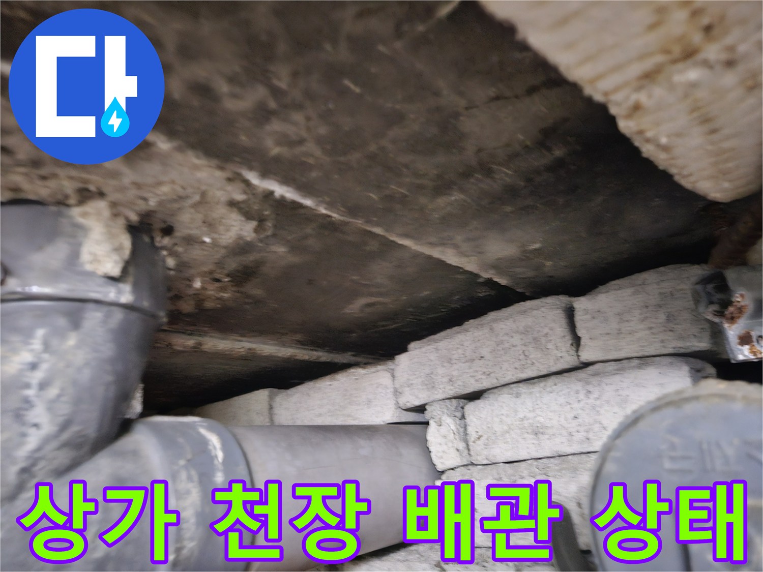일산 상가 천장 내부의 노후된 배관과 벽돌 구조물 모습