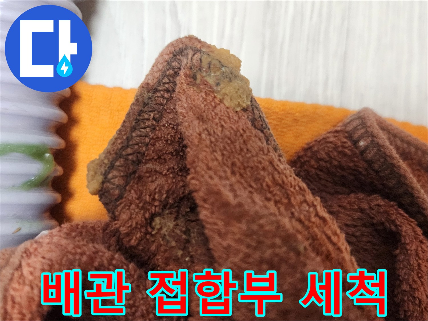 누수 탐지 후-배관 접합부에서 발견된 이물질을 깨끗하게 세척하는 장면