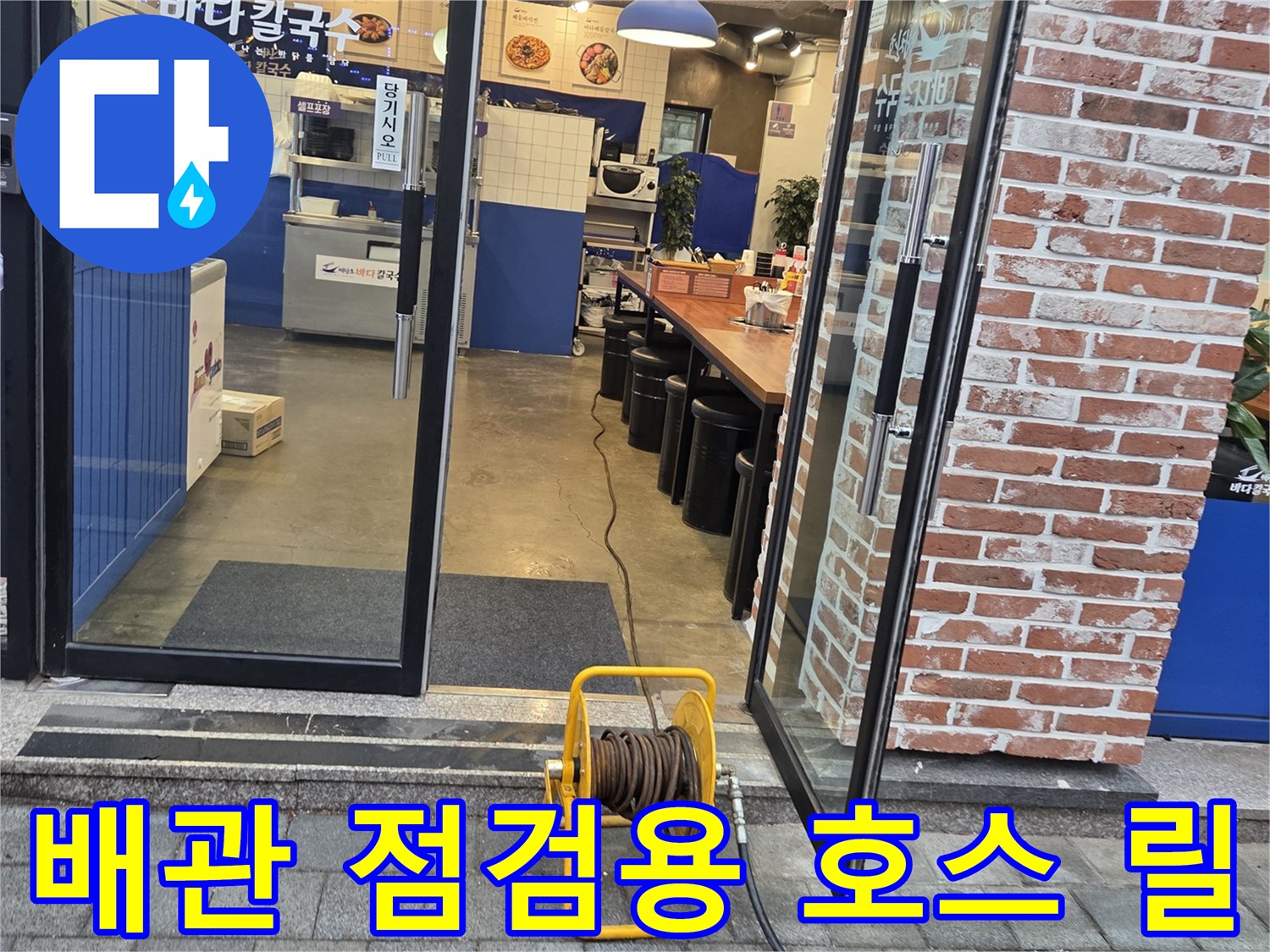 상가 건물 입구에 설치된 노란색 호스 릴 장비