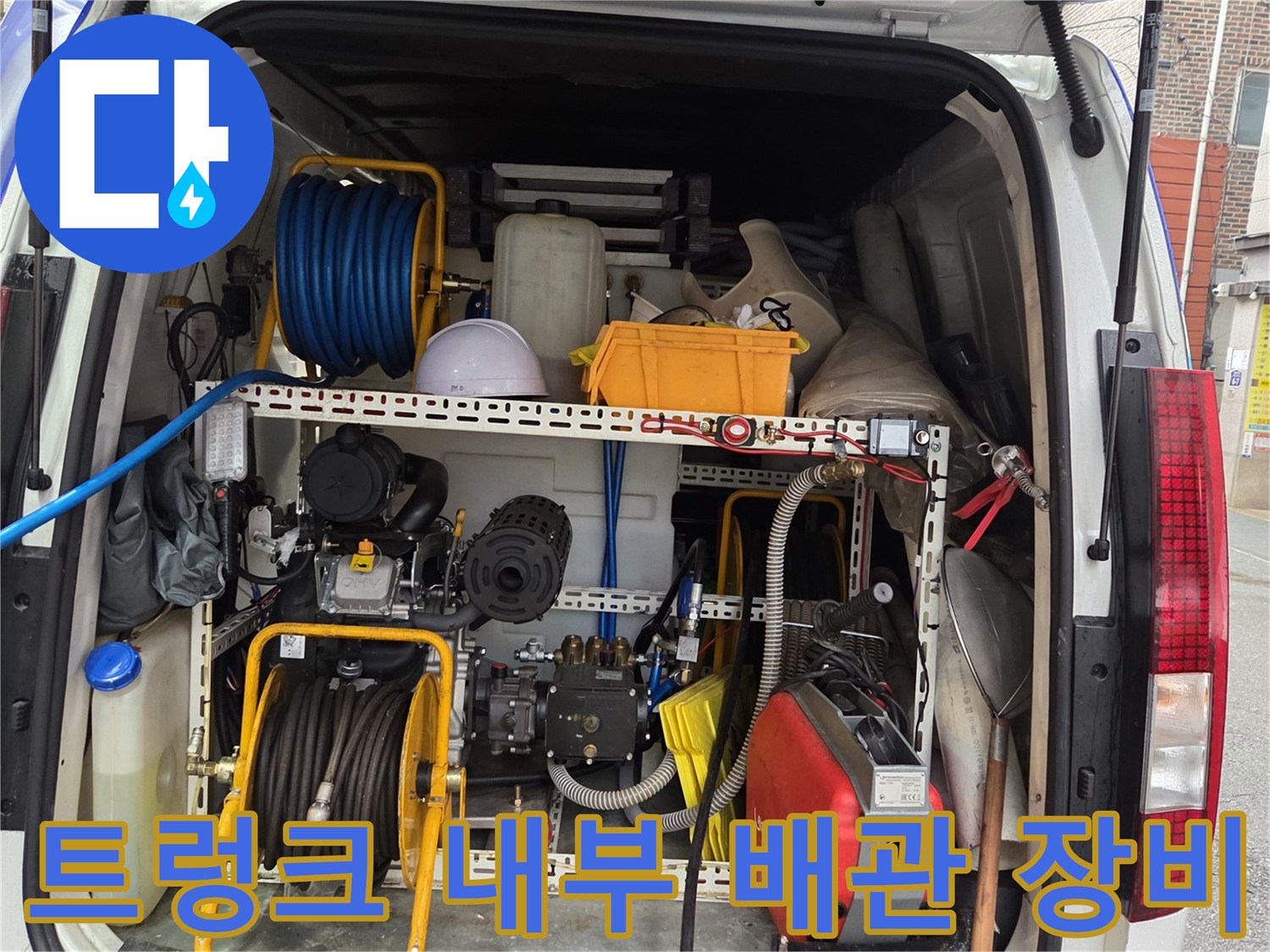 차량 내부에 체계적으로 정리된 하수구 세척용 고압 호스와 펌프 장치