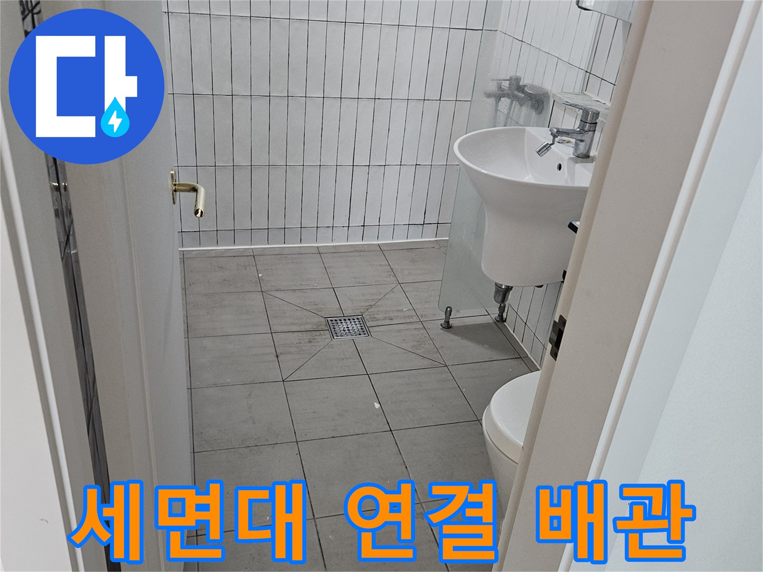 화장실 내부 세면대와 벽면 타일의 배관 구조 사진
