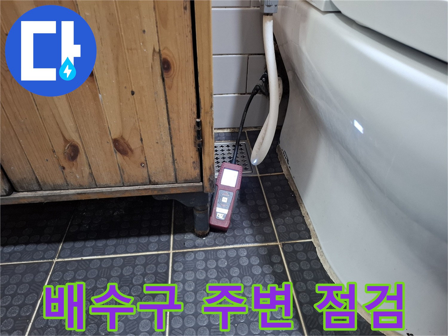 화장실 배수구 근처에 놓인 정밀 측정 장비와 타일 바닥