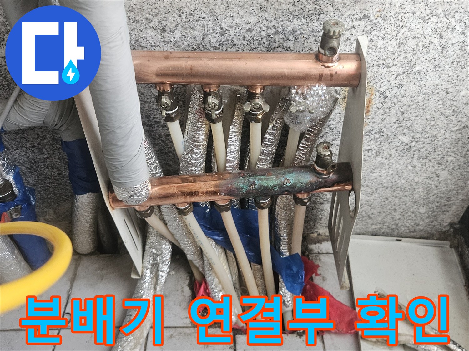 구리색 배관과 분배기 연결 부위의 상태를 보여주는 사진입니다.