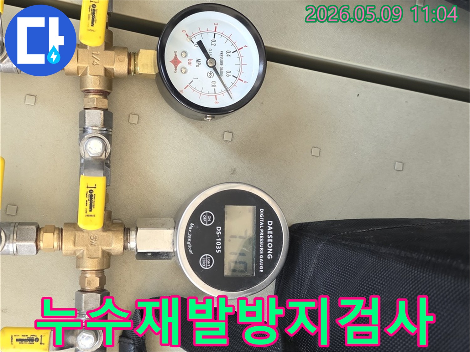 배관에 연결된 압력 게이지와 밸브를 통해-누수 재발 방지를 위한 철저한 검사를 진행하는 모습