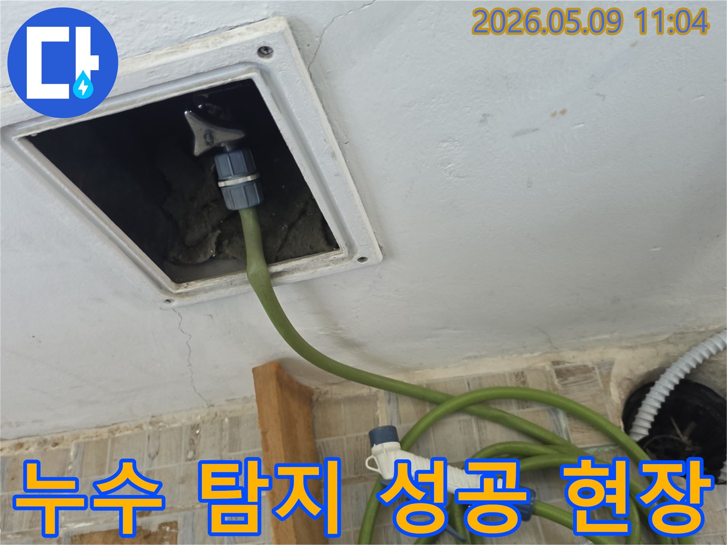 천장 점검구에 누수 탐지 호스를 연결하여 누수 지점을 성공적으로 찾아낸 현장 모습