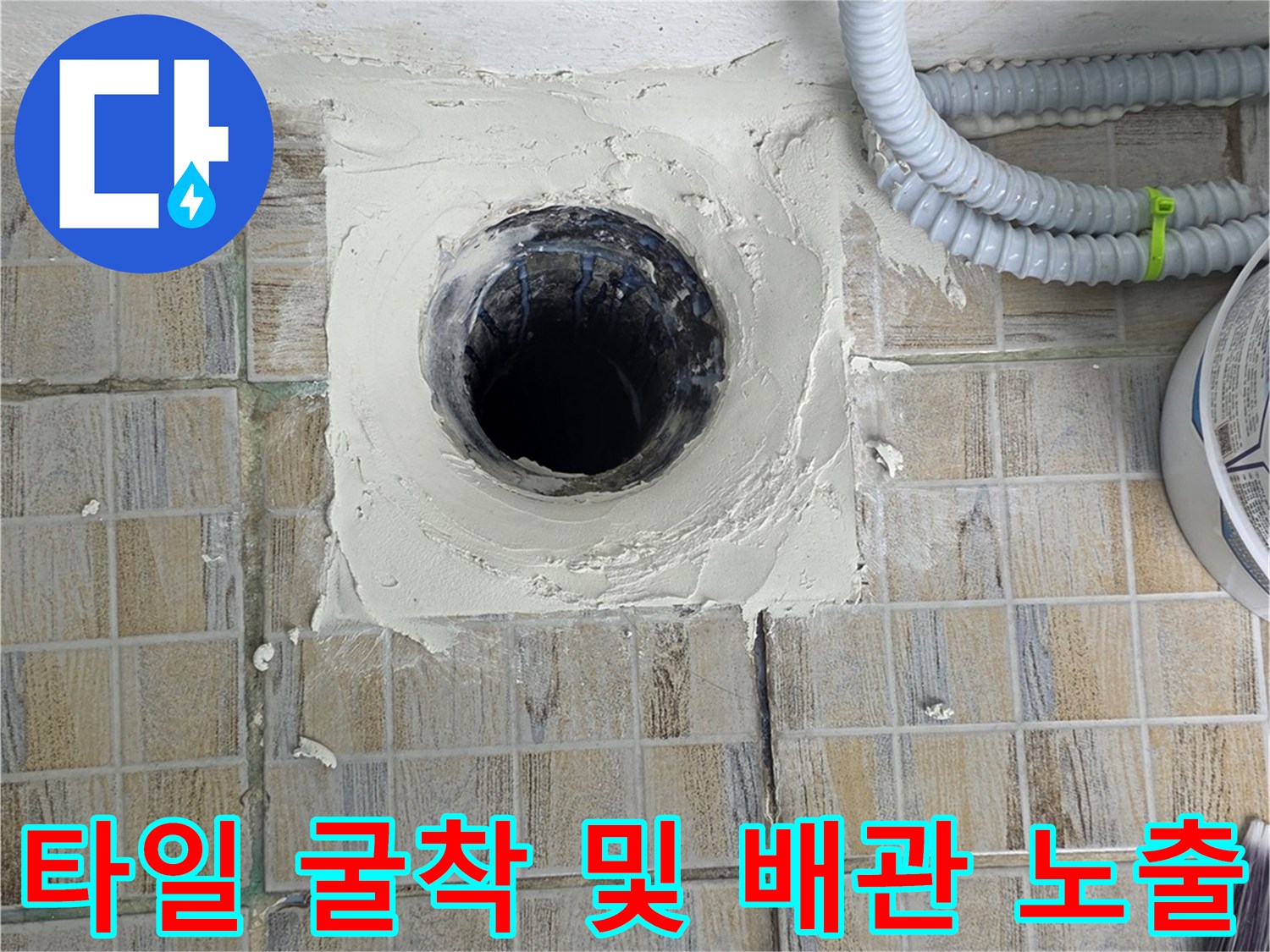 하수구 배관 주변의 타일을 제거하여 누수 지점을 확보한 장면입니다.