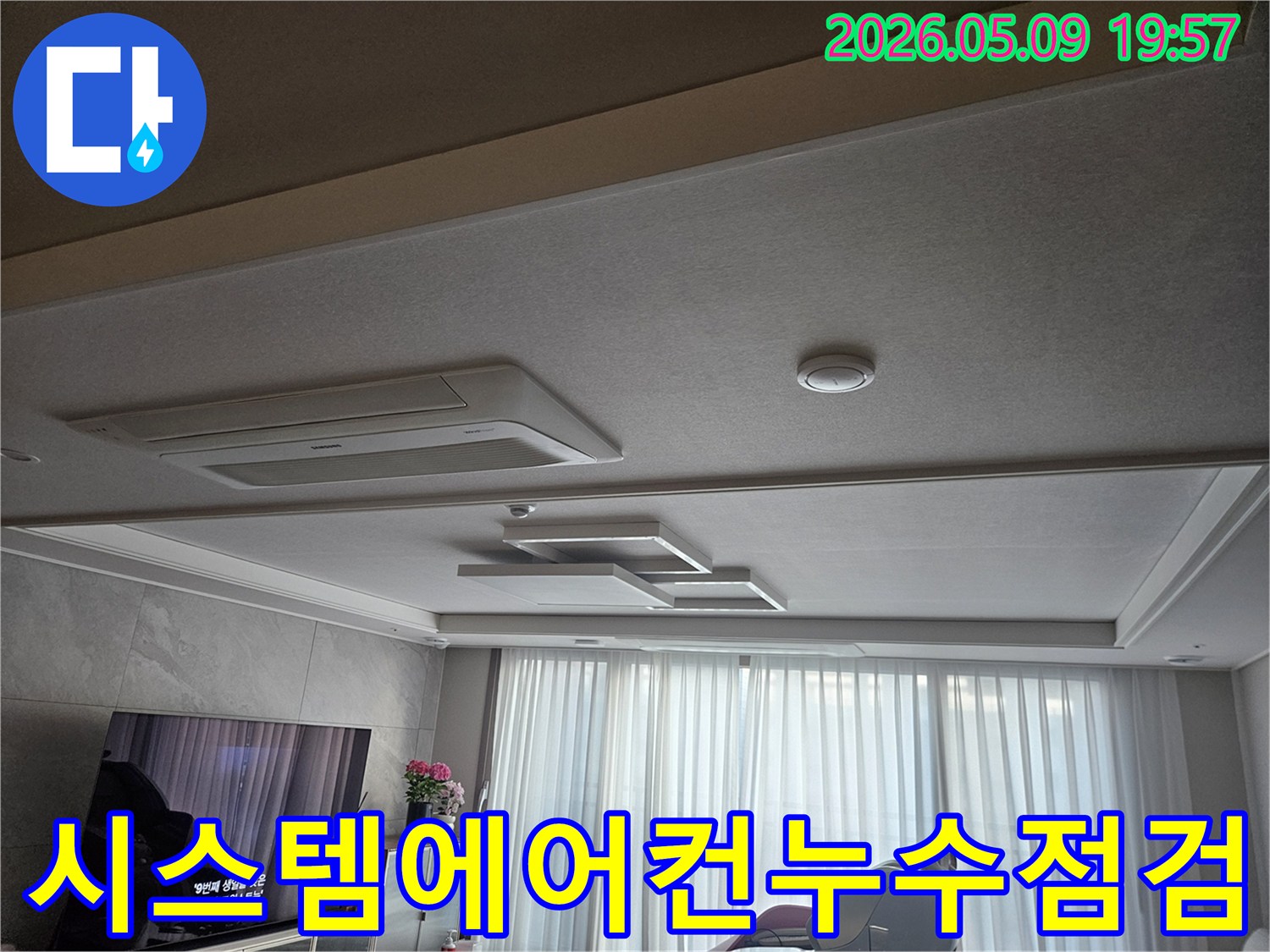 거실 천장에 설치된 시스템 에어컨 주변을 중심으로-누수 여부를 확인하는-엔지니어의 시선이 담긴 사진입니다.