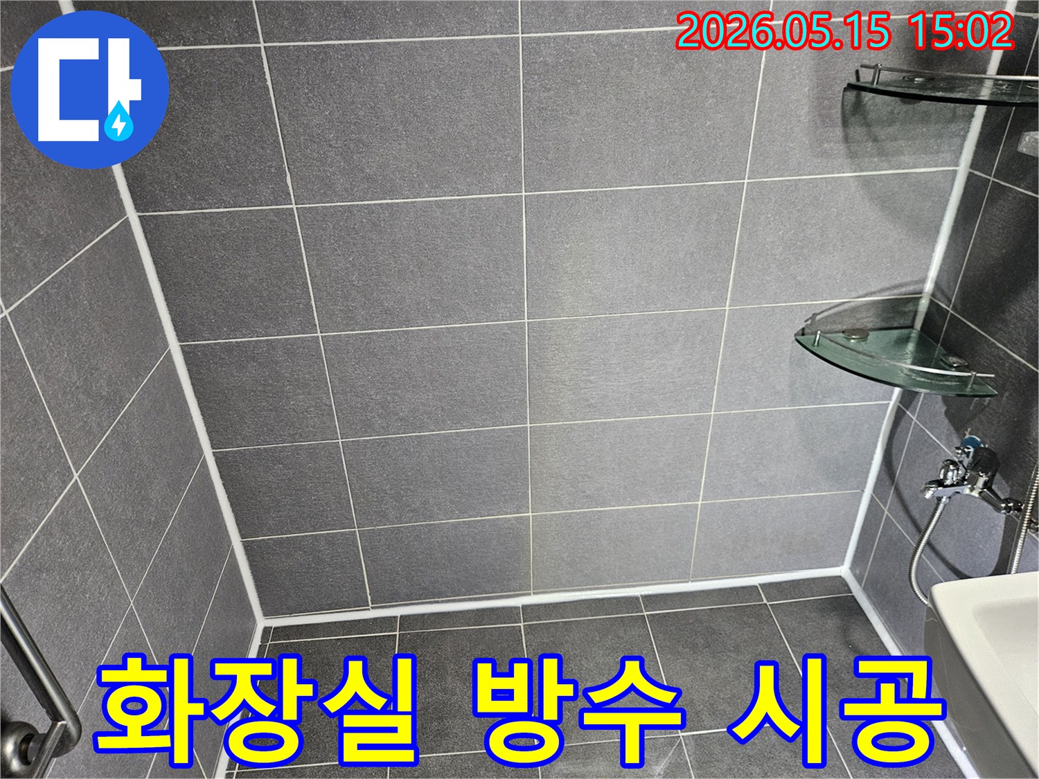 누수 문제 해결을 위해-새롭게 시공된-욕실의 타일과-하얀 줄눈 마감 상태