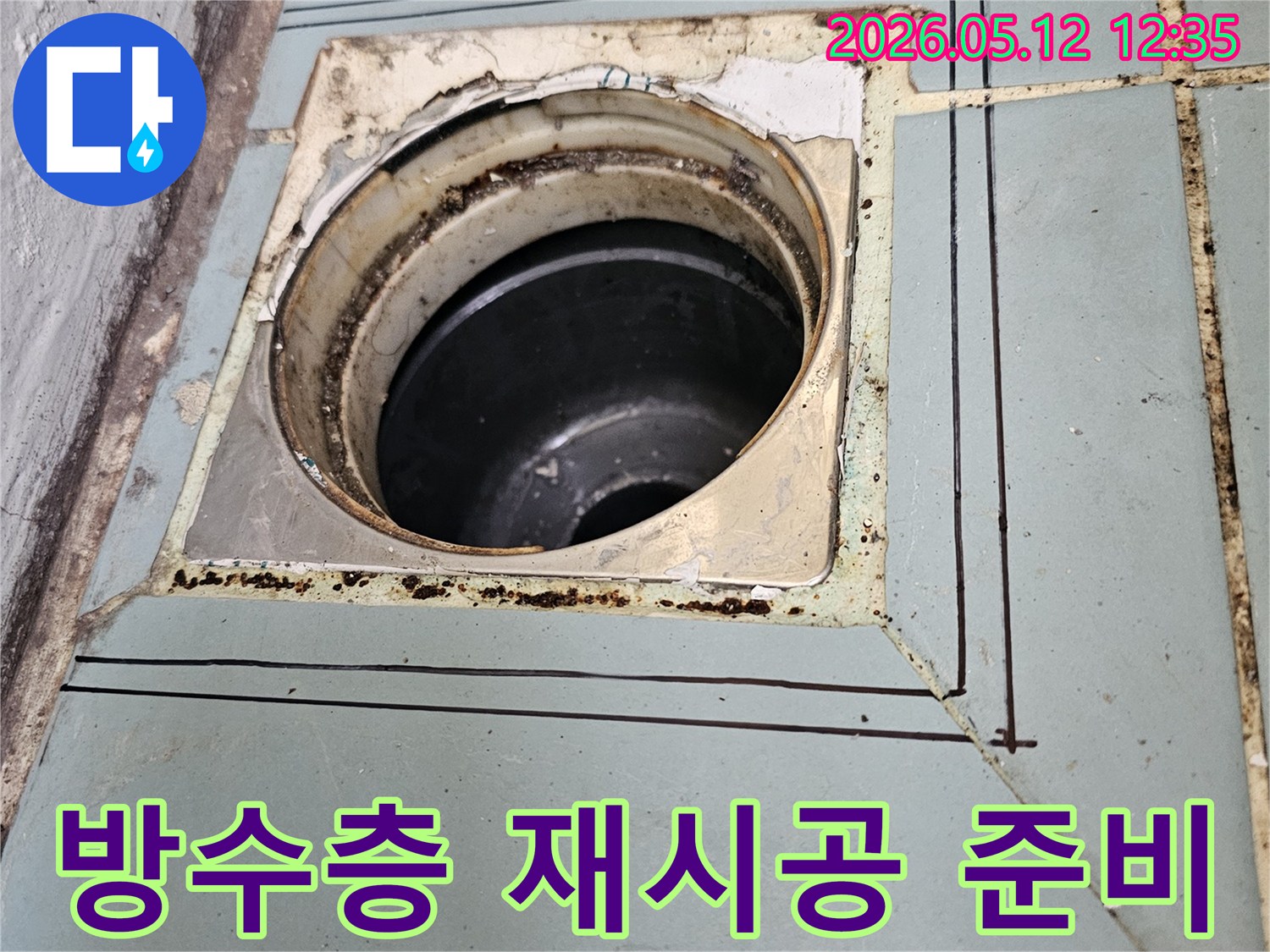 이 사진은-수원 영통 지역의-오래된 화장실 배수구 주변의-방수층 재시공을 위한-초기 준비 단계와-정확한 작업 범위를-보여주고 있습니다