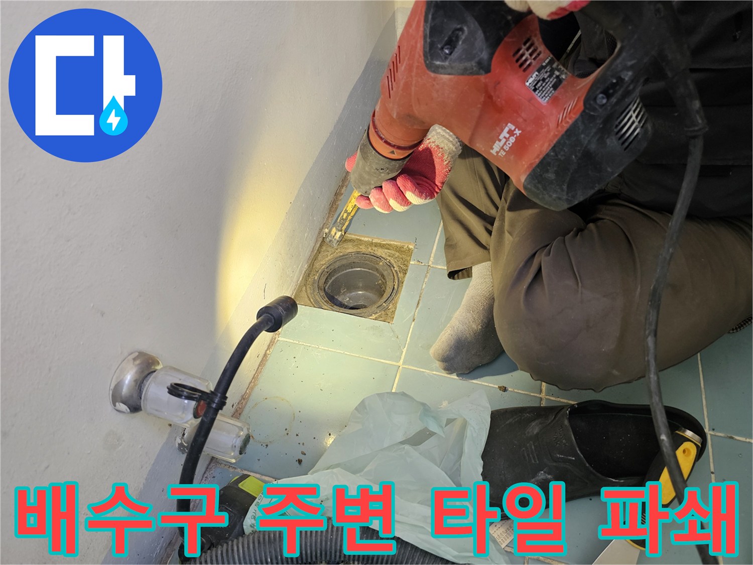 함마드릴로 세탁실 유가 부근의 타일을 떼어내는 공사 현장