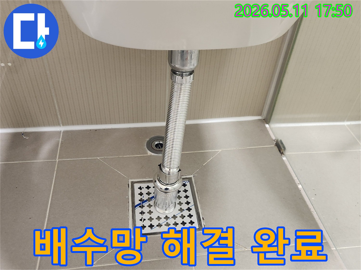 새롭게 설치된-욕실 바닥의-육가 배수망과-세면대 배수관의-깨끗하고-안정적인-연결 상태입니다.