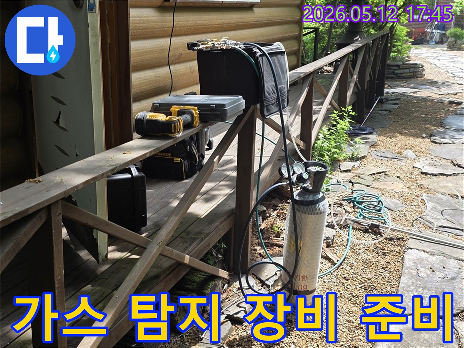 누수 탐지를 위한-가스통과 전문 도구들이-주택 옆 경사면에-정돈되어 있는 모습