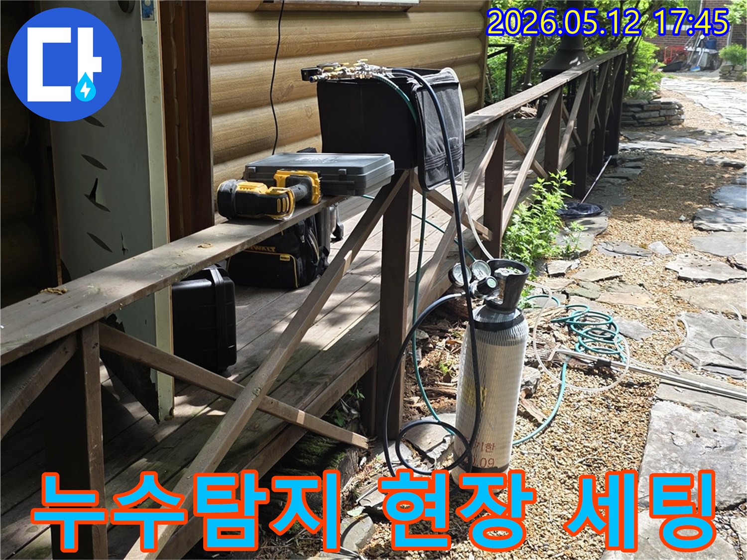 주택 옆 경사로에-누수 탐지용 가스통과-작업 도구들이-가지런히 놓여 있습니다