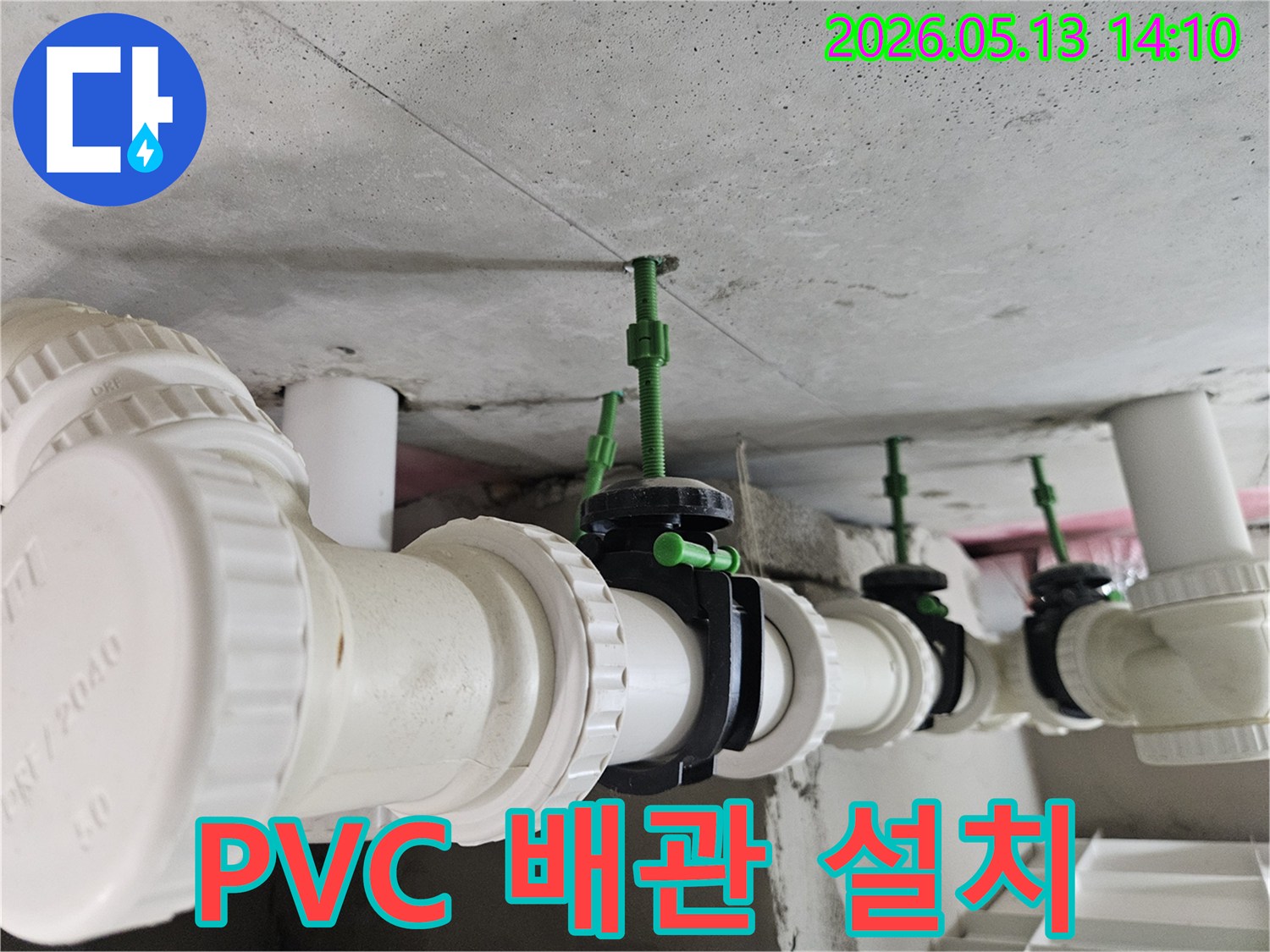 콘크리트 천장 아래에 설치된 하얀색 PVC 배관과-각 배관에 연결된 검은색 밸브의 견고한 모습