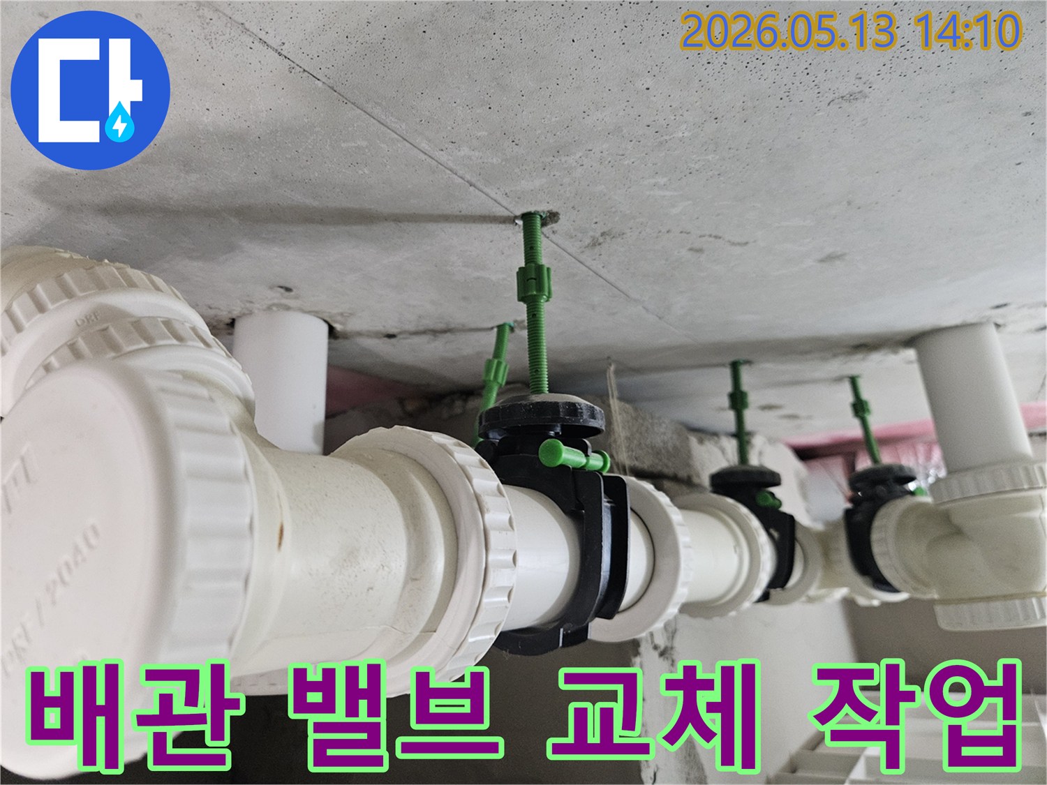 콘크리트 천장에 설치된 PVC 배관과-새롭게 교체된 검은색 밸브들이 일렬로 연결된 모습