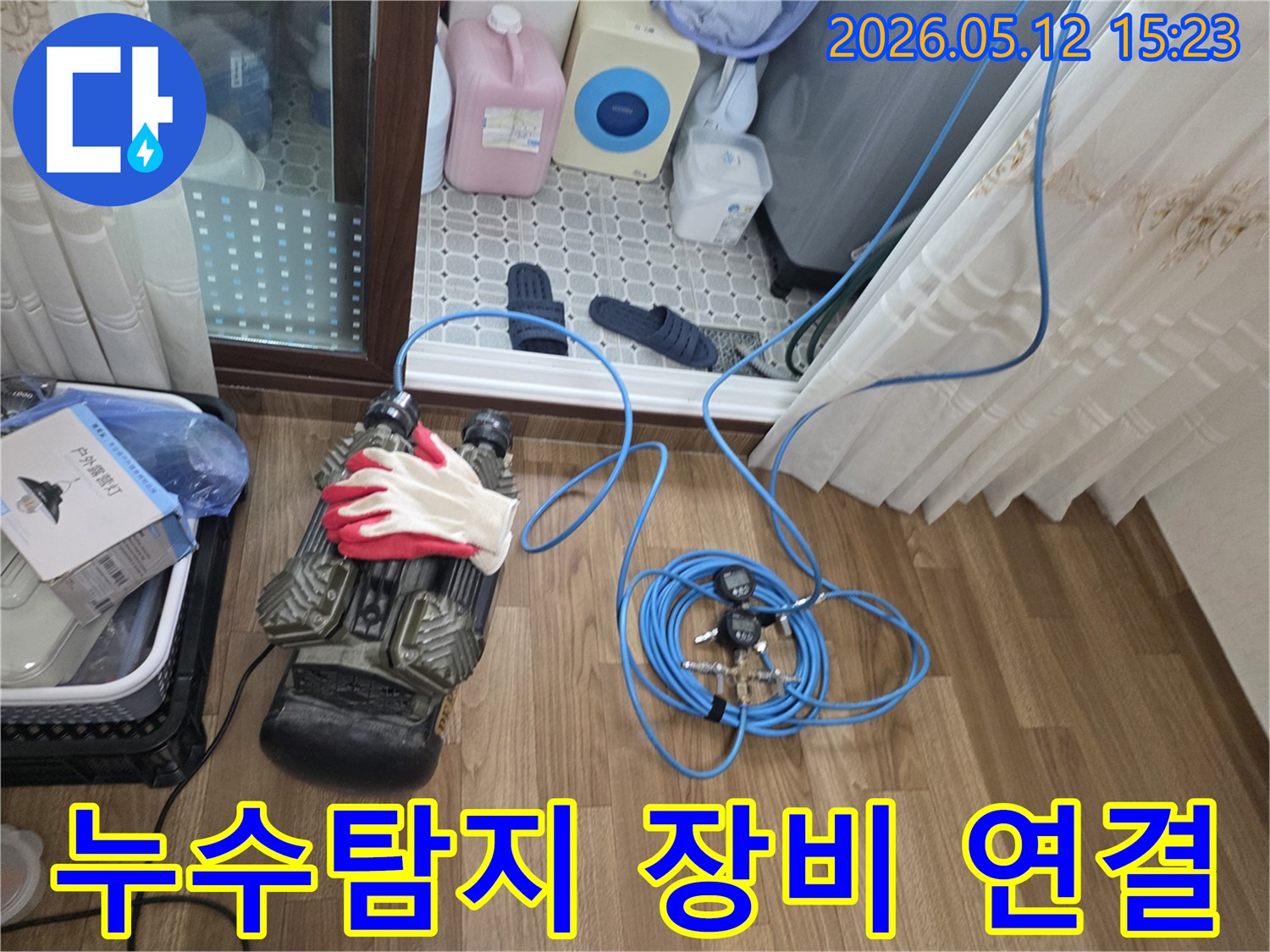 누수 지점을 찾기 위해 압력 테스트 장비와 파란색 호스를 연결하는 모습-정확한 진단을 위한 필수 단계