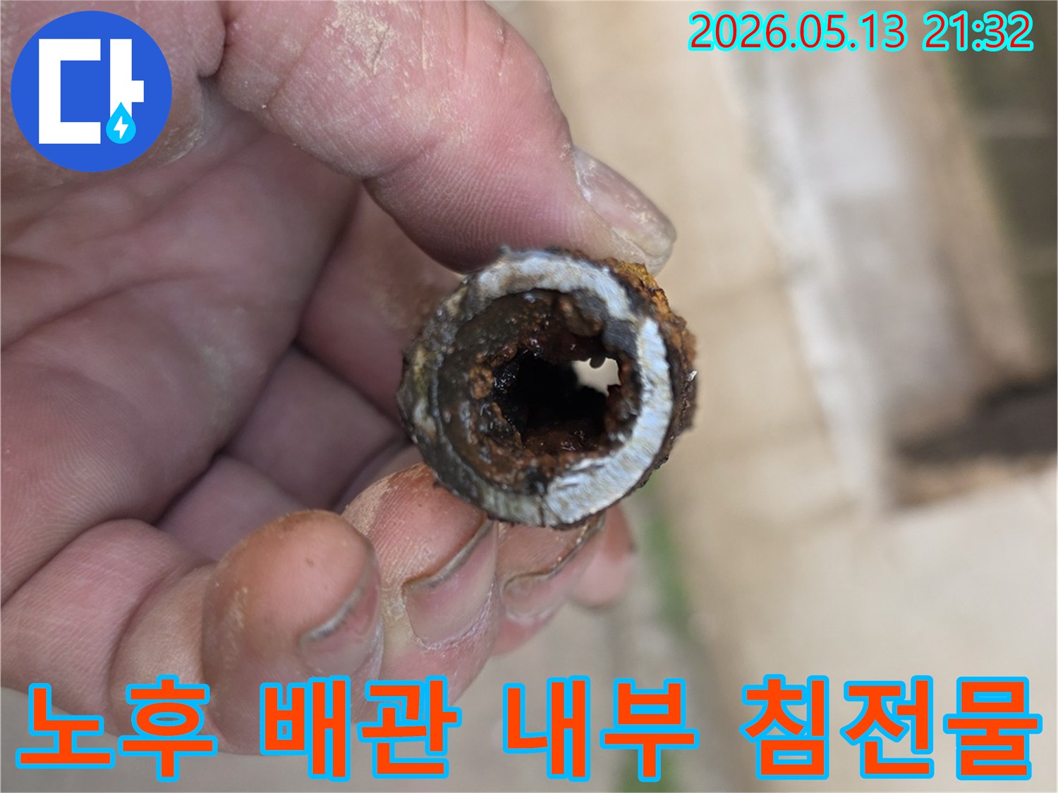 오래된 주택의 수도관 내부에서 발견된-심각한 침전물과 부식 상태를-전문가가 상세히 보여주는 모습입니다