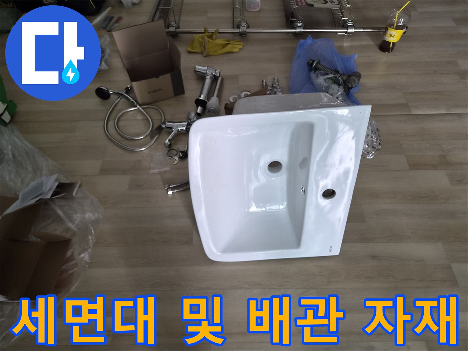 신규 설치를 위해 준비된 세면대 도기와 배관 연결 부품들입니다.