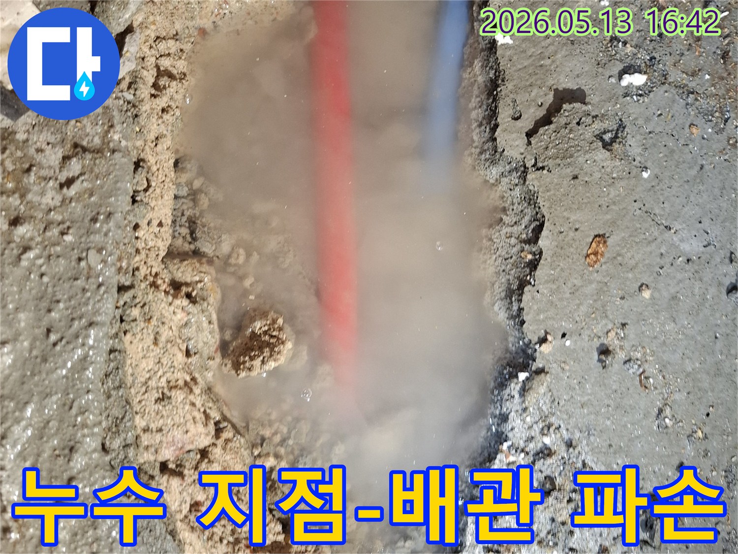 콘크리트 바닥을 파헤친 곳에서-흙탕물과 함께-붉은색과 푸른색 배관이 드러나고-뜨거운 물이 새는지-수증기가 피어오르는 모습
