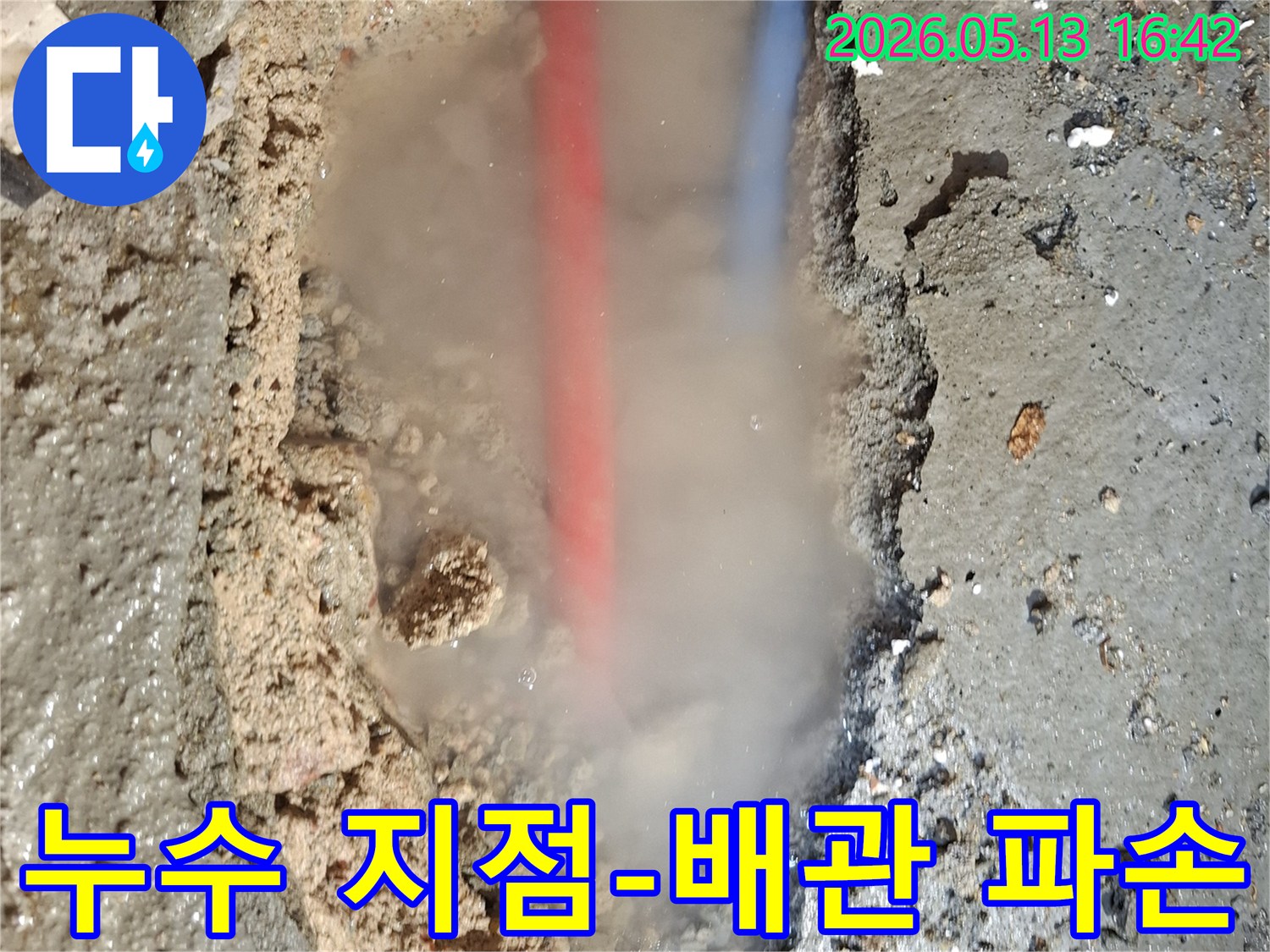 콘크리트 바닥을 파헤친 곳에서-흙탕물과 함께-붉은색과 푸른색 배관이 드러나고-뜨거운 물이 새는지-수증기가 피어오르는 모습