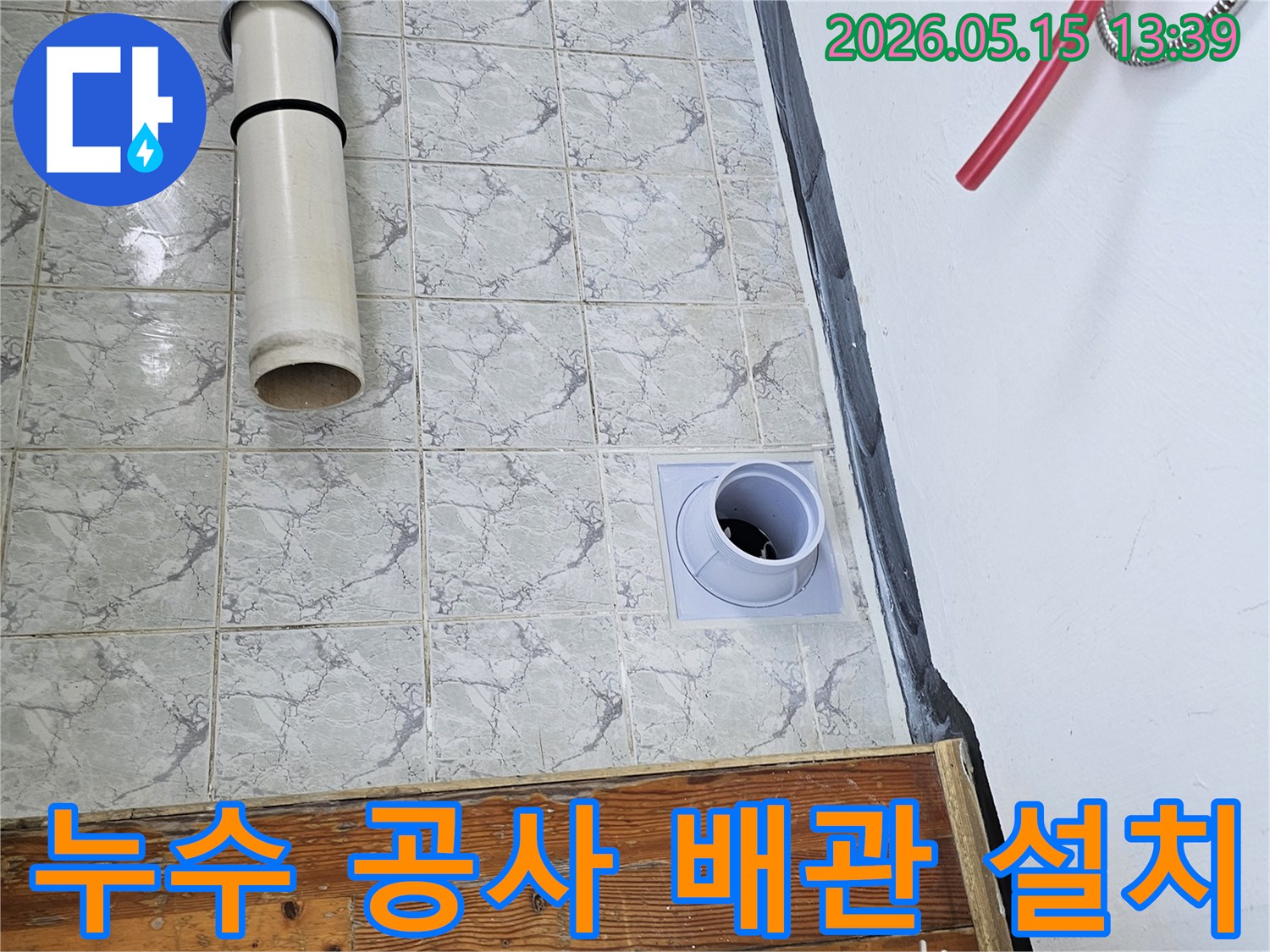 누수 공사 현장에서 배관 설치 작업이 진행되는 모습입니다-타일 벽면에 새로운 배관이 깔끔하게 시공되고 있습니다
