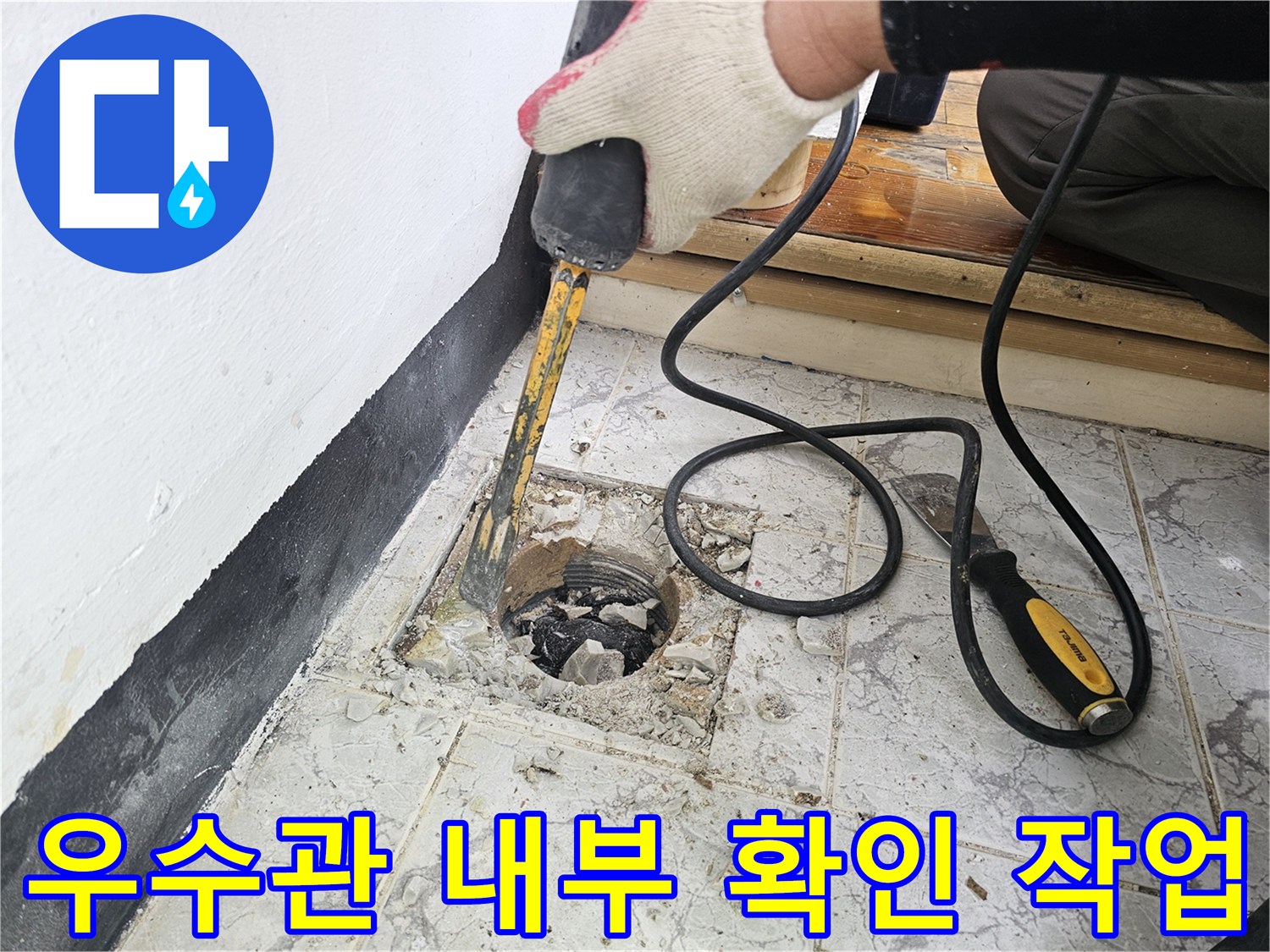 배관 주변의-오래된 시멘트와 타일을 제거하여 누수 지점을 노출시키는 장면