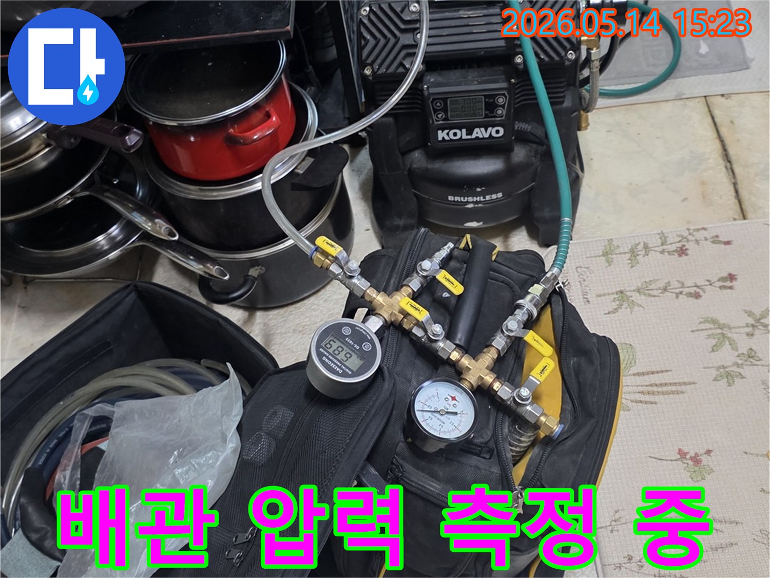 누수 탐지를 위해 배관에 연결된 압력 테스트 장비가 작동 중인 모습