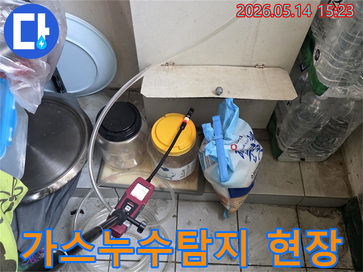 이 사진은 누수-탐지-전문가가-가스-누수-탐지기를-활용하여-숨겨진-누수-지점을-찾아내는-모습을-담고-있습니다