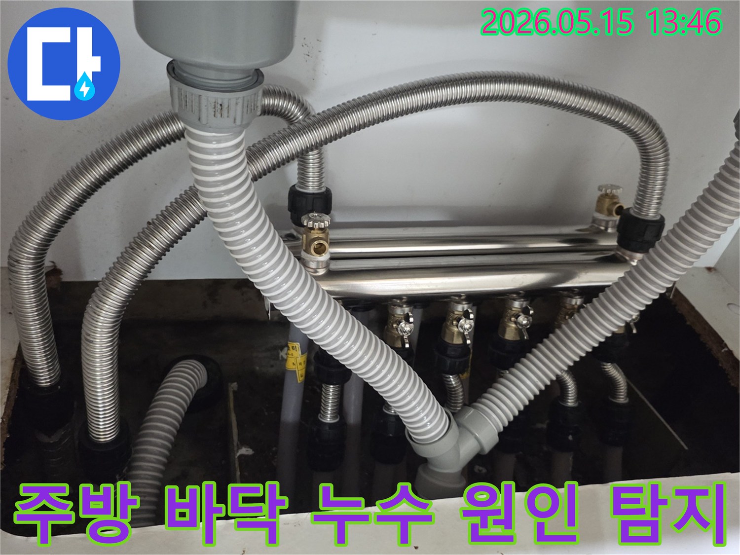 주방-바닥에-물이-고여있고-배관-주변에서-누수가-발생한-상황을-보여줍니다