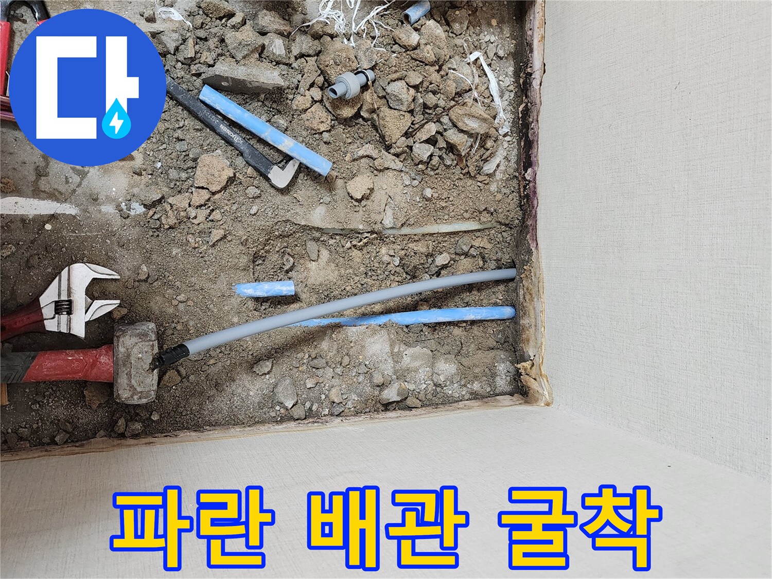 흙더미-사이에-드러난-파란색-배관과-공구류