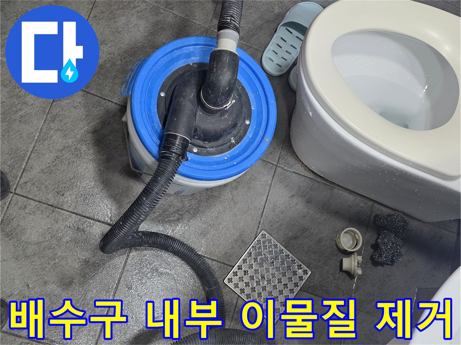 화장실 바닥 유가 근처에 배치된 석션 호스와 청소 장비의 모습입니다.