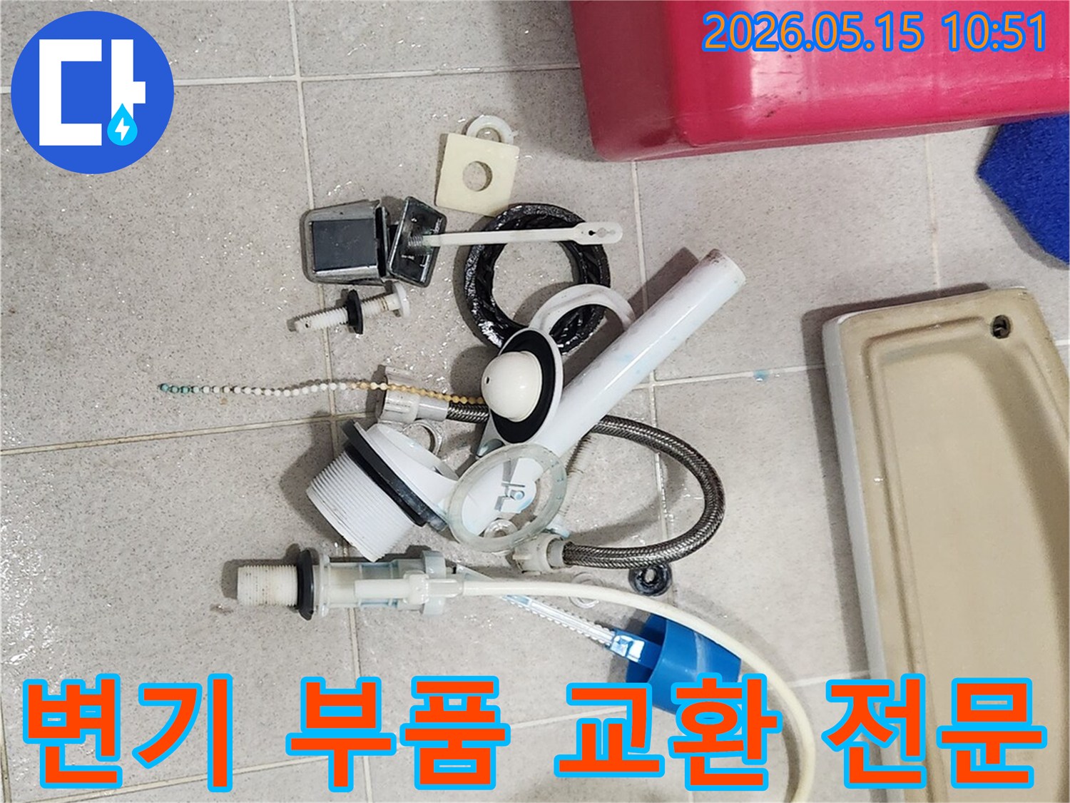 오랜 사용으로 기능이 저하된 변기 부속품들이-바닥에 놓여-새 부품으로 교체될 준비를 하고 있습니다