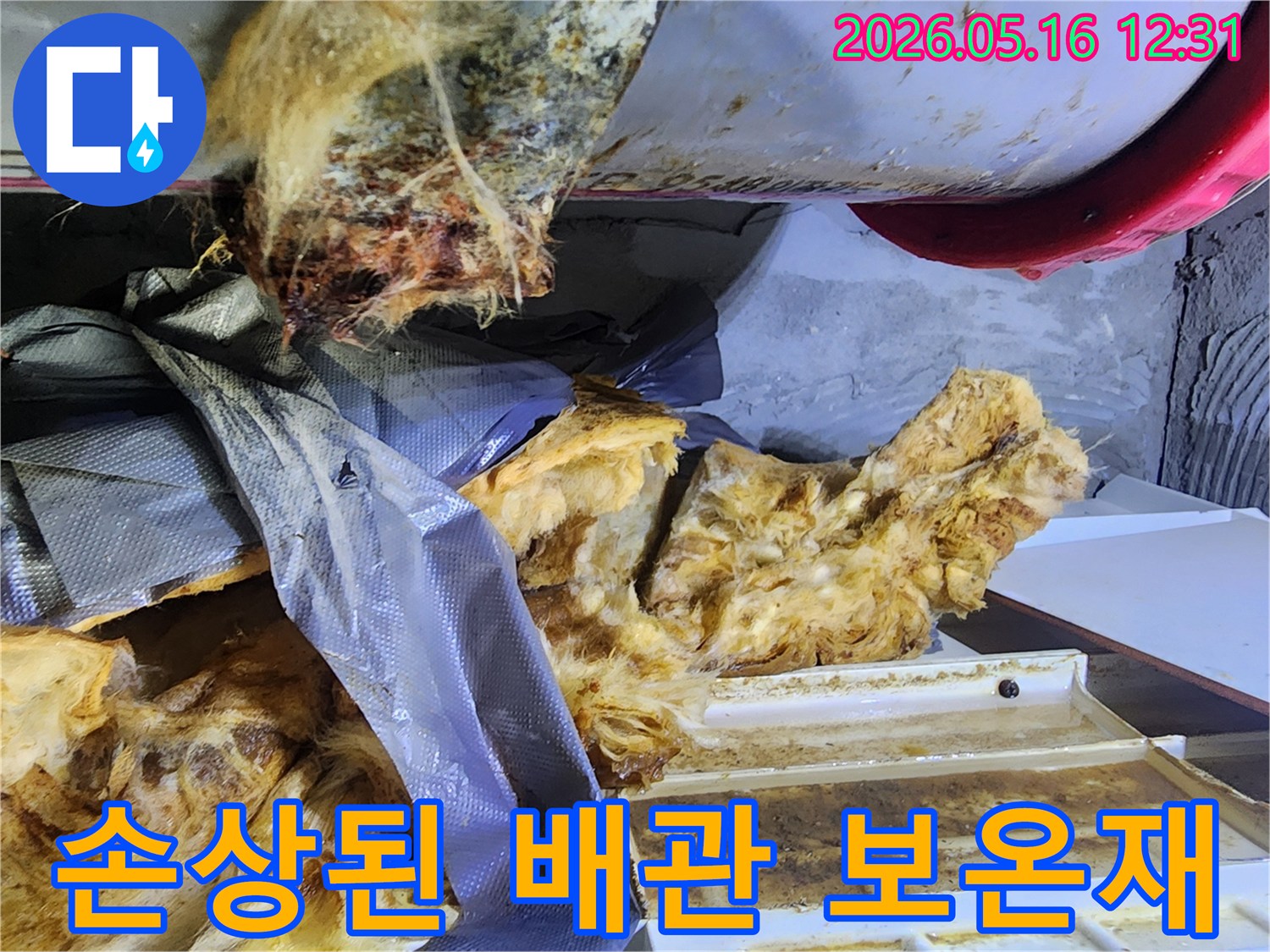 물기로 인해 찢어지고 훼손된 배관 보온재와 노출된 배관의 모습-입니다